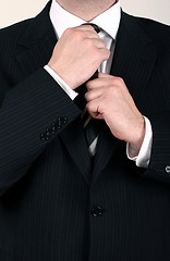 Image showing Businessman adjusting his tie