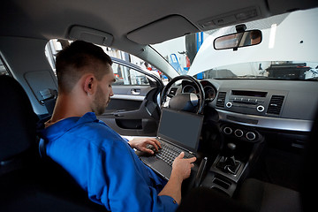 Image showing mechanic man with laptop making car diagnostic