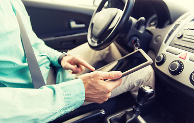 Image showing close up of young man with tablet pc driving car