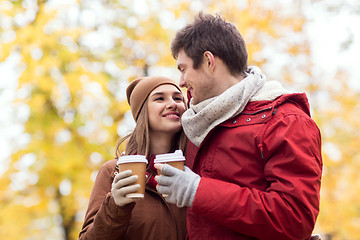 Image showing happy couple with coffee walking in autumn park