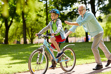 Image showing grandfather and boy with bicycle at summer park