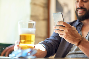 Image showing close up of man with smartphone and beer at pub