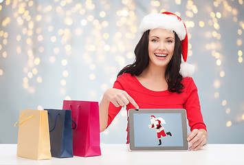 Image showing woman in santa hat with tablet pc and shopping bag