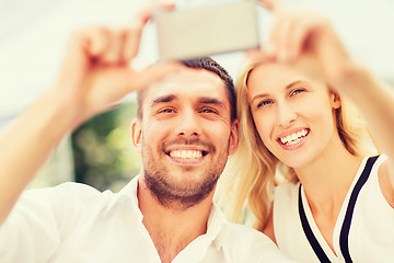 Image showing happy couple taking selfie with smartphone 