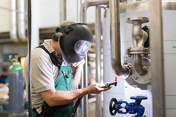 Image showing Industrial worker welding in metal factory.