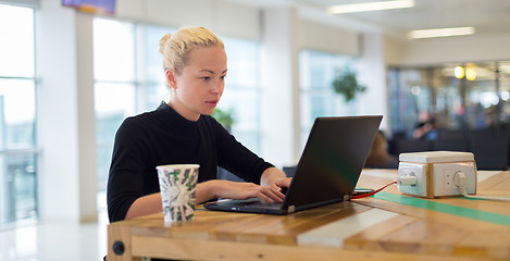 Image showing Female freelancer remotely working on the go.