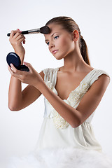 Image showing Young Woman Applying Cosmetics