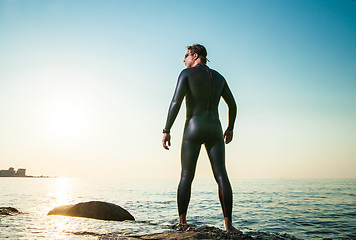 Image showing Man in diving suit standing in waves