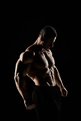 Image showing torso of attractive male body builder on black background.