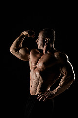 Image showing torso of attractive male body builder on black background.