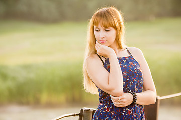 Image showing Portrait of a pensive modest girl on blurred green background