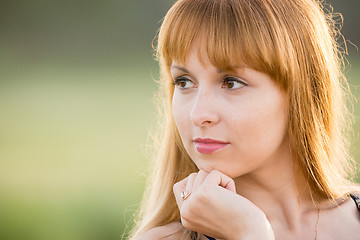 Image showing Up portrait of a girl gazing to the left, creating a soft green background