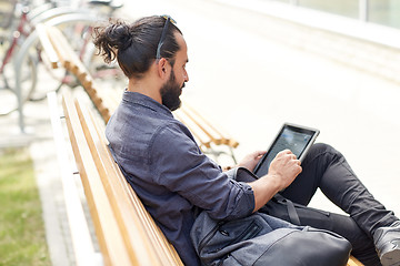 Image showing man with tablet pc sitting on city street bench