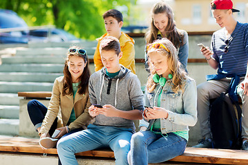 Image showing happy teenage friends with smartphones outdoors