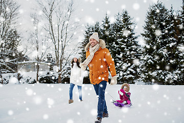 Image showing happy family with sled walking in winter outdoors