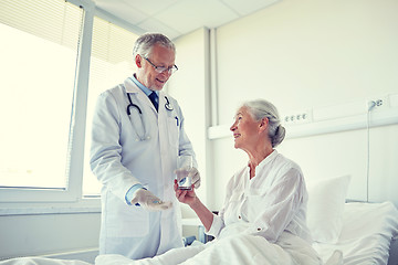 Image showing doctor giving medicine to senior woman at hospital