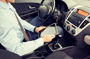 Image showing close up of young man with tablet pc driving car