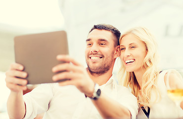 Image showing happy couple with tablet pc at restaurant lounge