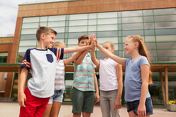 Image showing group of children making high five at school yard