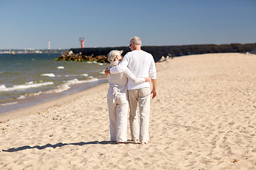 Image showing happy senior couple hugging on summer beach