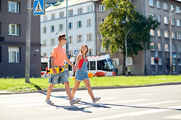 Image showing teenage couple with skateboards on city street