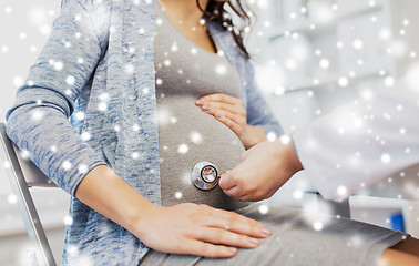 Image showing doctor with stethoscope and pregnant woman belly