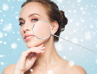 Image showing beautiful woman with magnifier on face over snow