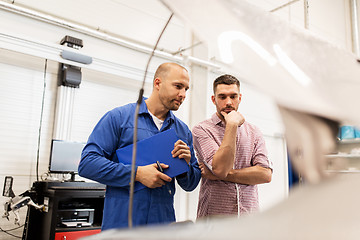 Image showing auto mechanic with clipboard and man at car shop