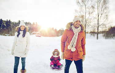 Image showing happy family with sled walking in winter outdoors