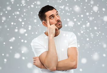 Image showing man thinking over snow on gray background