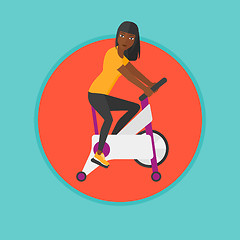 Image showing Woman riding stationary bicycle.