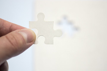 Image showing Hand holds suitable piece of puzzle