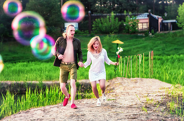 Image showing Young Couple Running On The Grass