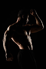 Image showing torso of attractive male body builder on black background.