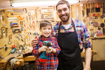 Image showing father and son with drill working at workshop