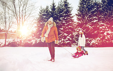 Image showing happy family with sled walking in winter outdoors