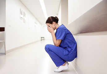 Image showing sad or crying female nurse at hospital corridor