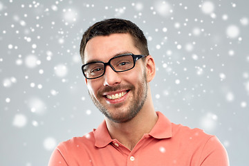 Image showing happy smiling man in eyeglasses over snow