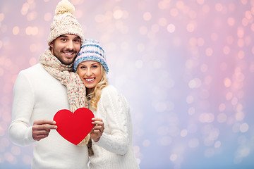 Image showing smiling couple in winter clothes with red hearts