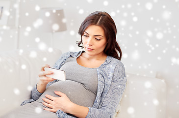 Image showing sad pregnant woman with smartphone at home