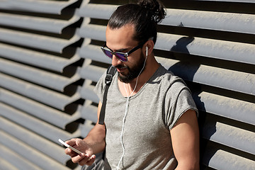 Image showing man with earphones and smartphone on city street