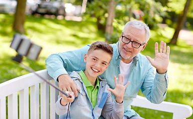 Image showing old man and boy taking selfie by smartphone