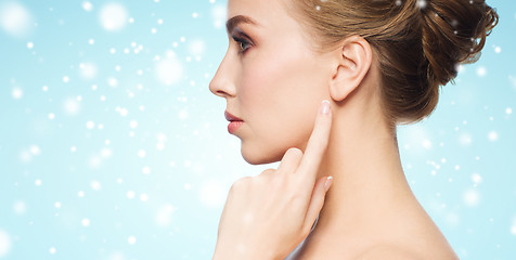 Image showing close up of woman pointing finger to ear over snow
