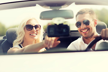 Image showing happy couple usin gps navigation system in car