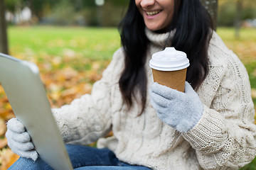 Image showing woman with tablet pc and coffee cup in autumn park