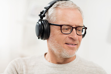 Image showing happy man in headphones listening to music at home