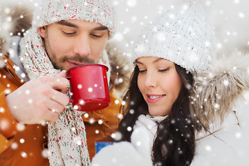 Image showing happy couple with tea cups over winter landscape