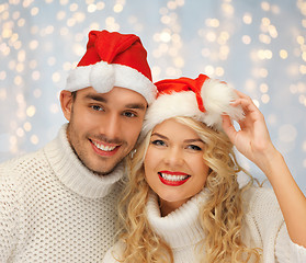 Image showing happy family couple in sweaters and santa hats
