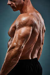 Image showing torso of attractive male body builder on gray background.