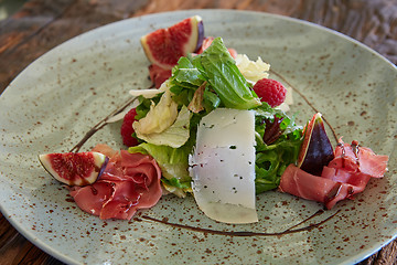 Image showing Fresh salad with figs, prosciutto and goat cheese